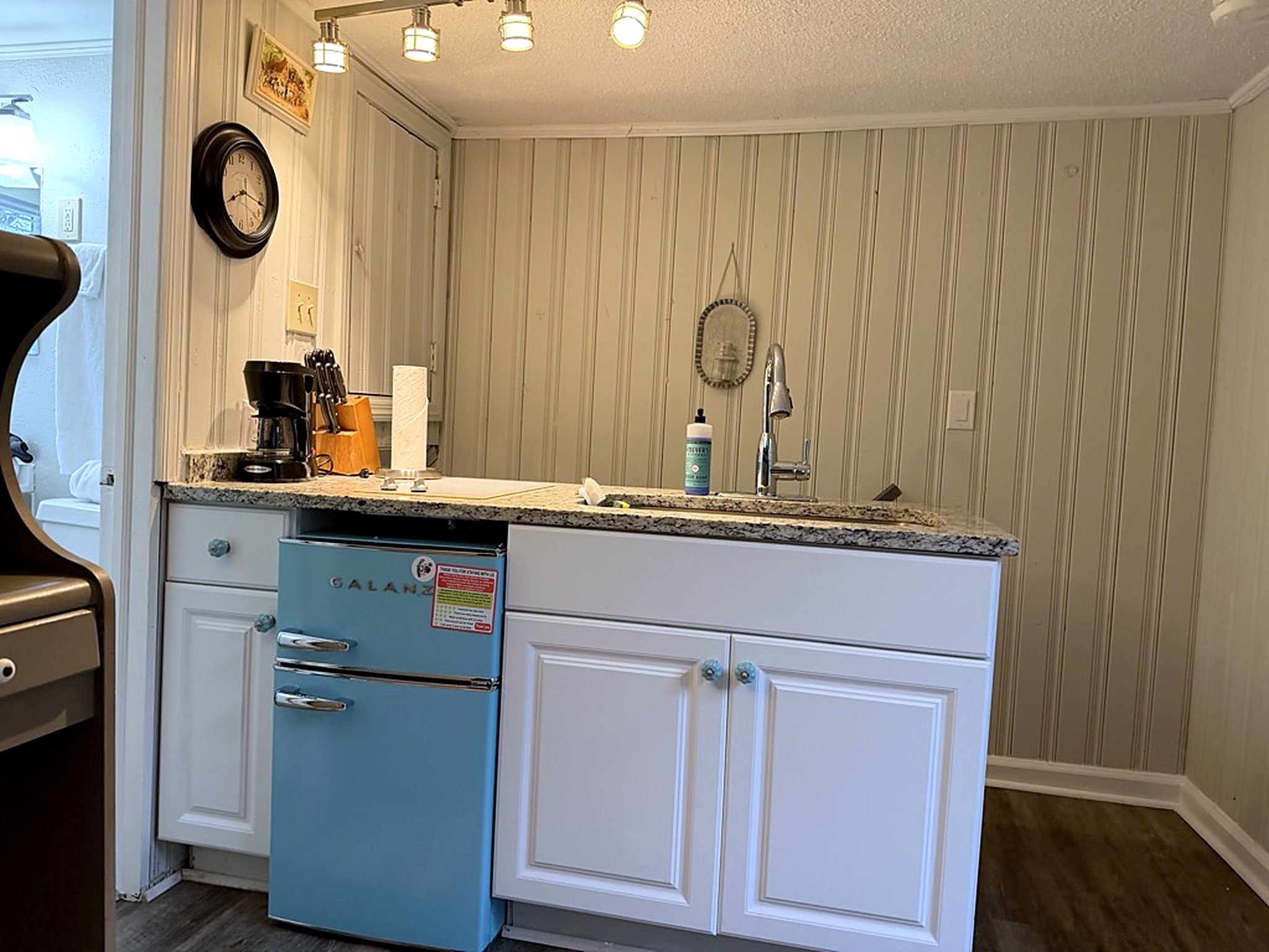 Charming kitchenette with retro mini fridge, coffee station, and bright lighting