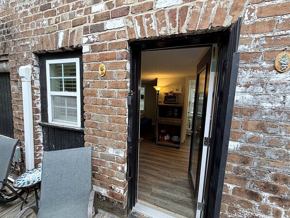 A brick exterior with a door leading to an interior space.