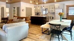 A modern kitchen with wooden cabinets, a central island, and pendant lighting.