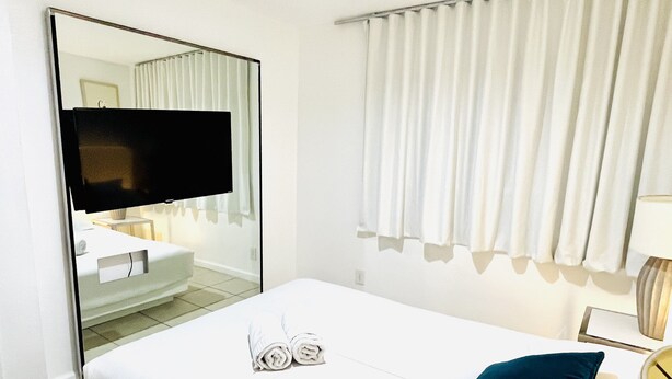 A hotel room with a bed, a TV, a bathroom, and a window with curtains. - 2BRpartment,LasVegas,Strip,Pet-friendly,Lvcc,SALE,BestSpot,Sema Show,Labor day (Las Vegas)