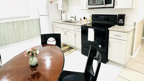 A modern kitchen with white cabinets, a microwave, stove, and a coffee maker. - 2BRpartment,LasVegas,Strip,Pet-friendly,Lvcc,SALE,BestSpot,Sema Show,Labor day (Las Vegas)
