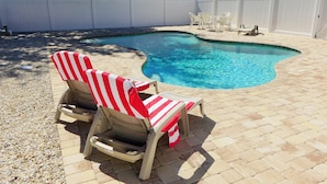 A swimming pool with two lounge chairs and a table. - Dream holiday at a great price – now with massive discounts! (Fort Myers)