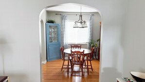 A dining area with a round wooden table and chairs, a blue cabinet, and a chandelier. - Make your visit to the beautiful city of Berea memorable! (Berea)