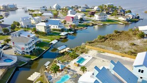 Zona residencial costera con casas, muelles y piscina.
