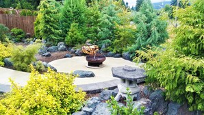 A garden with a fire pit, rocks, and various shrubs. - Reconnect ~ Relax ~  Rejuvenate ~ Explore ~  Larch Avenue Getaway (Port Angeles)