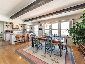 A spacious kitchen with a central island, wooden chairs, and a dining table set for six. - S.O.B. (Sweet Ol' Bill) | Oceanfront + Pets! (Surf City)