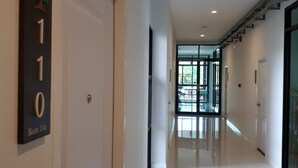 A modern hotel corridor with a clean, reflective floor and a door labeled "Baan Lila".