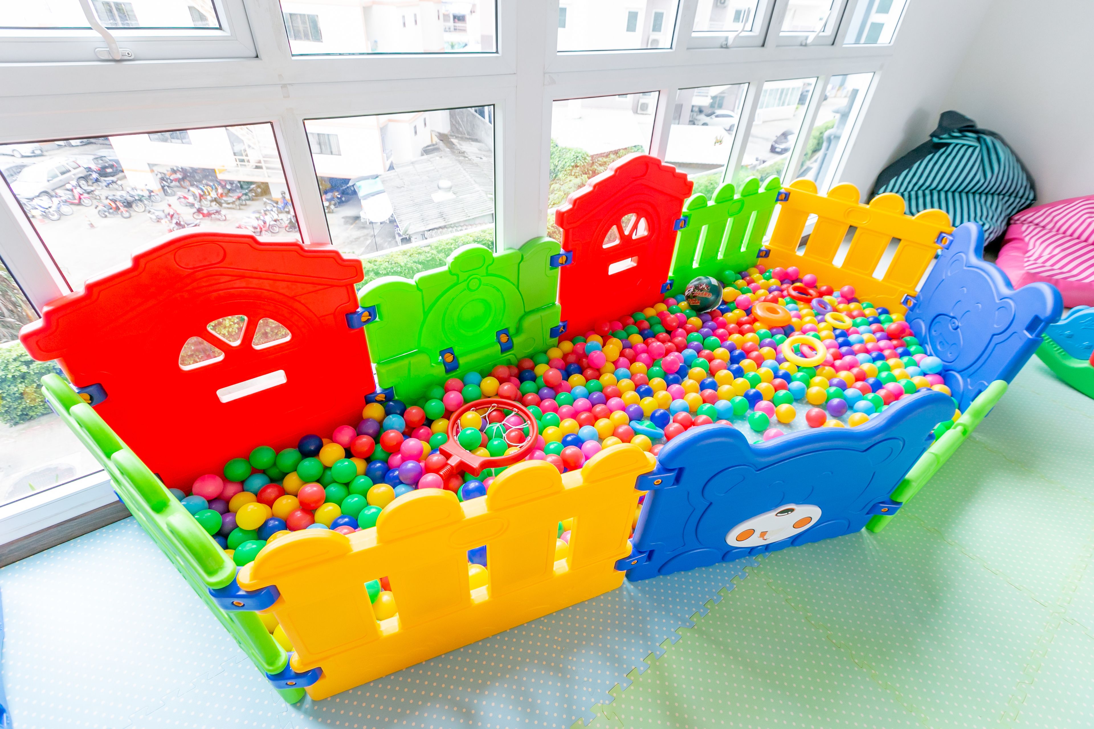 Un'area giochi al coperto colorata, con una piscina di palline e strutture ricreative.
