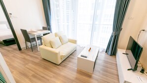 A modern living room with a sofa, a coffee table, a TV, and a desk. - Locals ChiangMai Central Airport Plaza (Chiang Mai)
