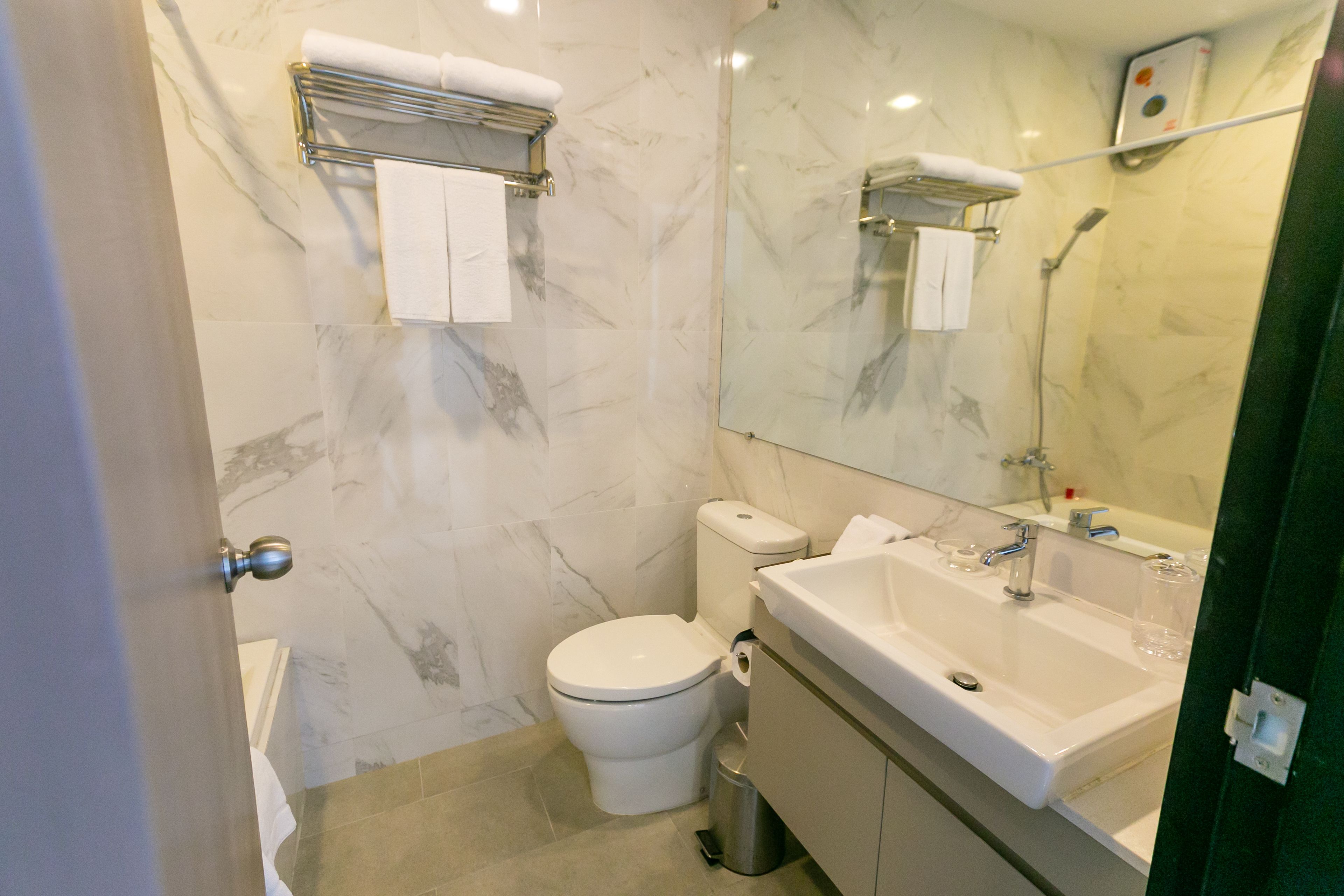Een badkamer met toilet, wastafel en spiegel.