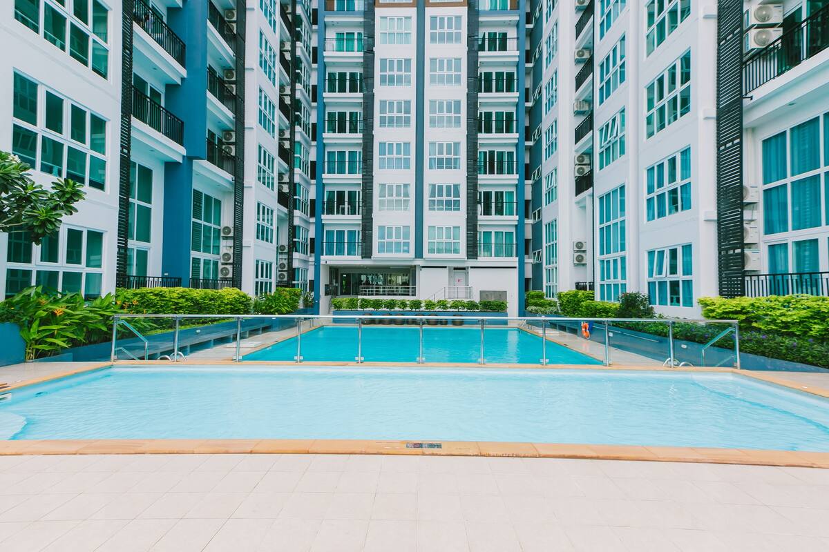 A modern building with a central swimming pool surrounded by balconies.