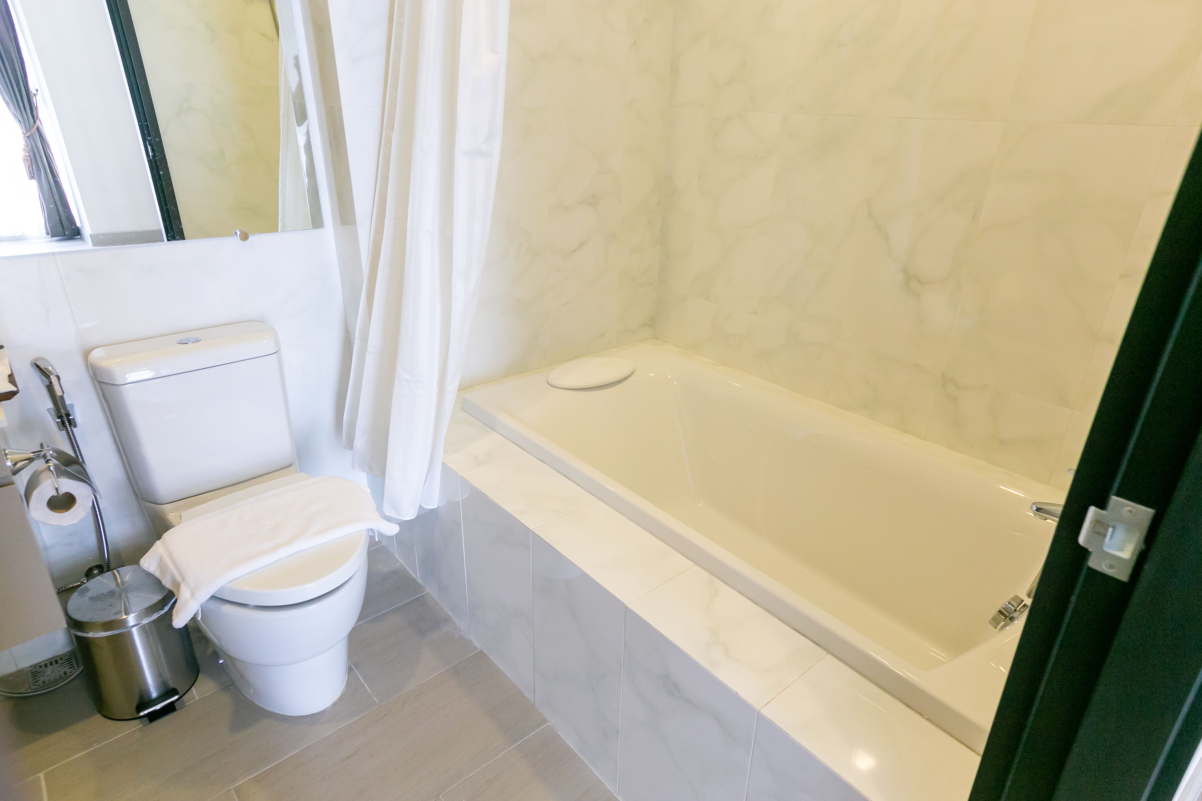 Une salle de bain équipée de toilettes, d’une baignoire et d’un rideau de douche.