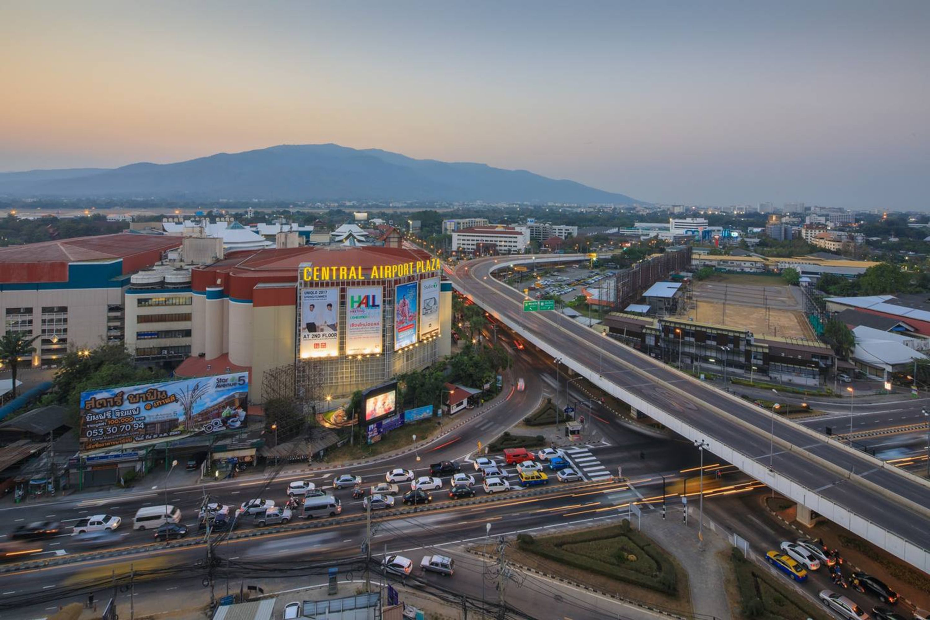 Un nudo de autopistas con varios niveles y un edificio destacado en primer plano, identificado con el rótulo 'Central Airport Plaza'.