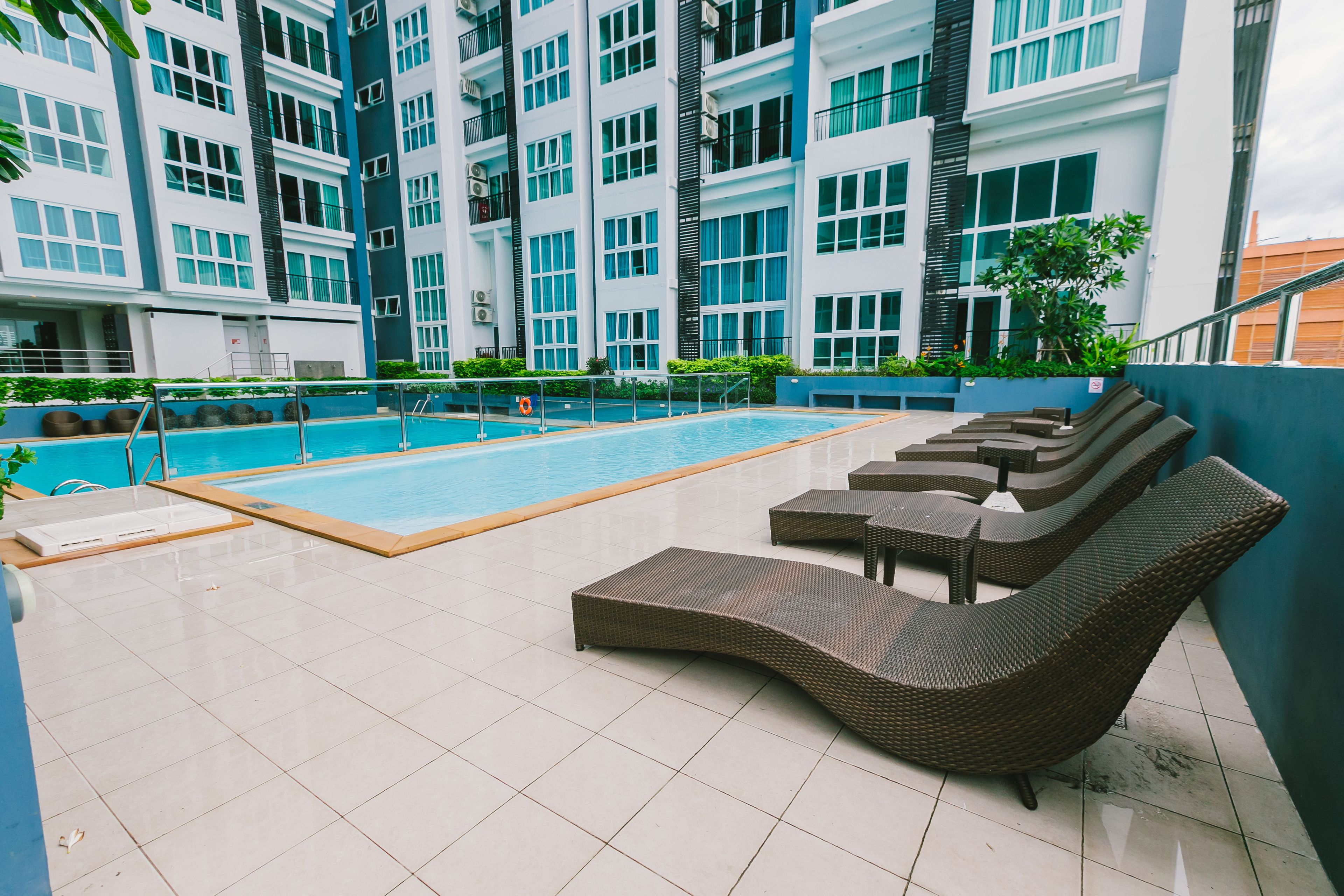 A rooftop pool area with lounge chairs and a swimming pool.