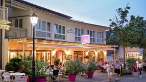 A restaurant with outdoor seating, a signboard, and potted plants. - Luisenstuben (Badenweiler)