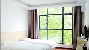 A hotel room with two beds, a large window with curtains, a wooden floor, and a desk with a coffee maker. - DONG JIANG HU XIANG CUN DA WAN CAI Hotel (Chenzhou)