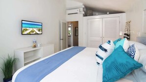 Een slaapkamer met een bed, een televisie aan de muur en een kast.