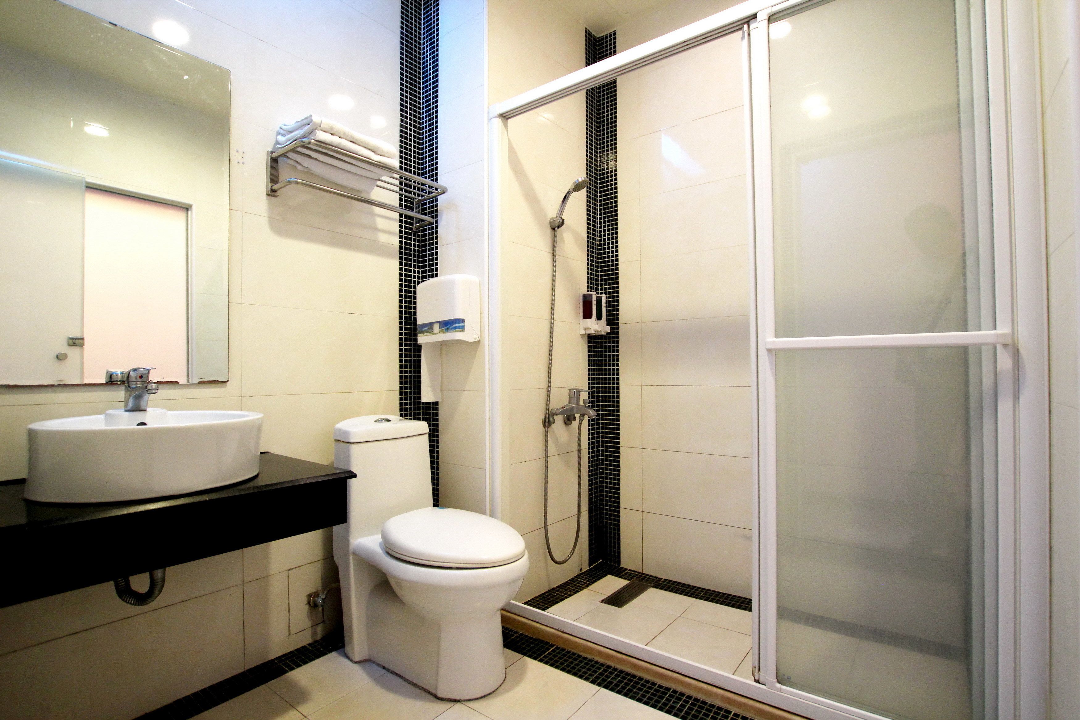 A modern bathroom with a white sink, toilet, and glass-enclosed shower.