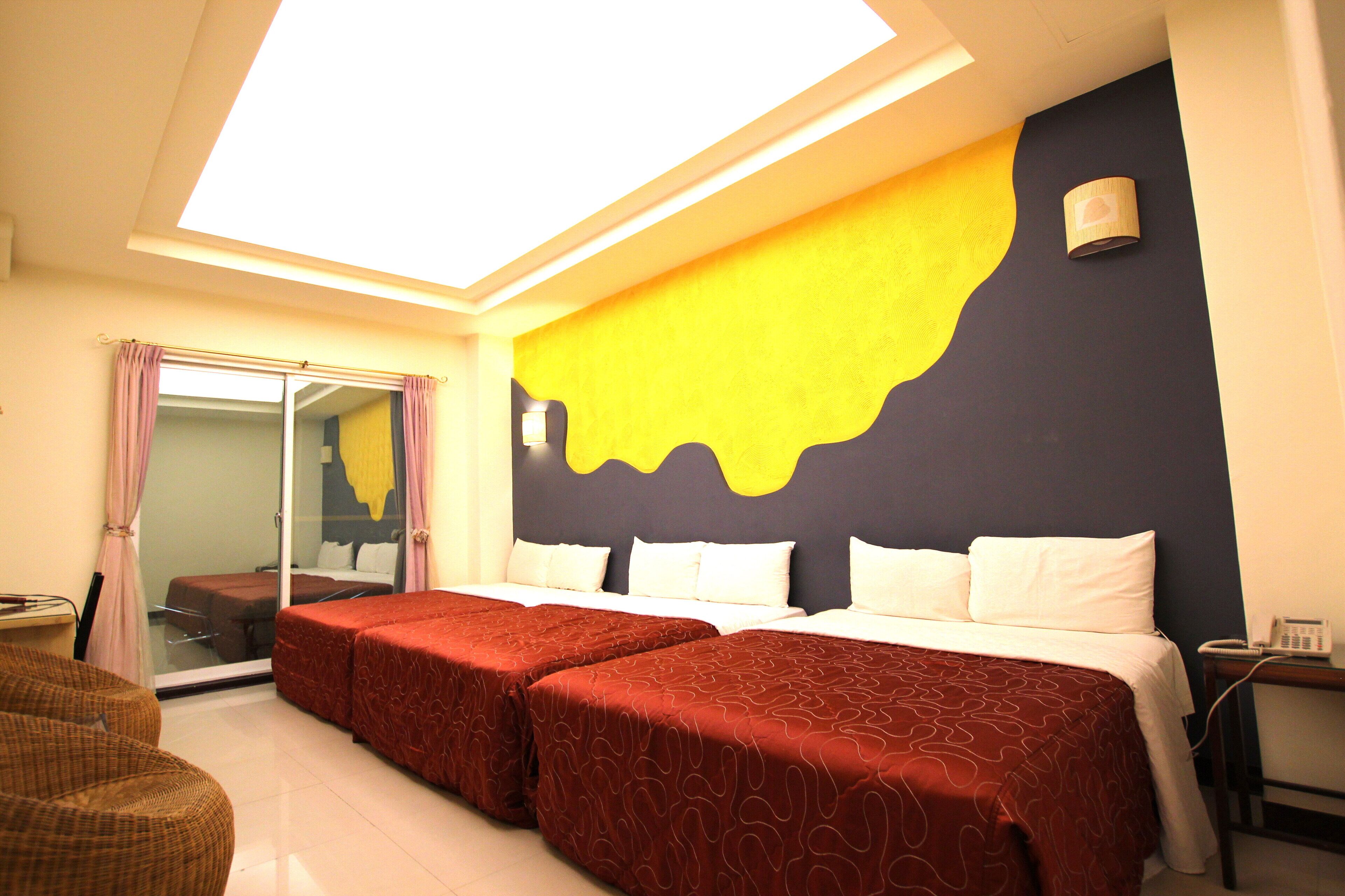 Una habitación de hotel con una cama grande, una mesita pequeña y un espejo.