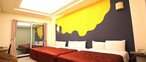Una habitación de hotel con una cama grande, una mesita pequeña y un espejo.