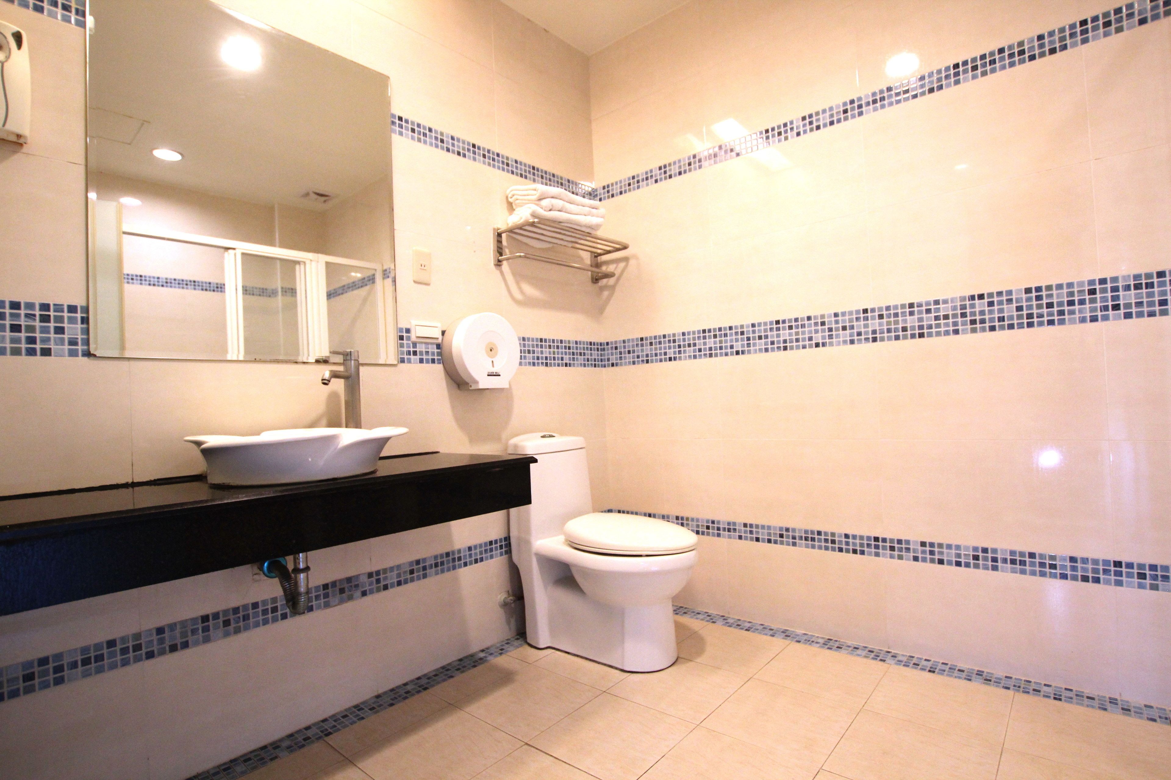 A bathroom with a sink, toilet, and a mirror.