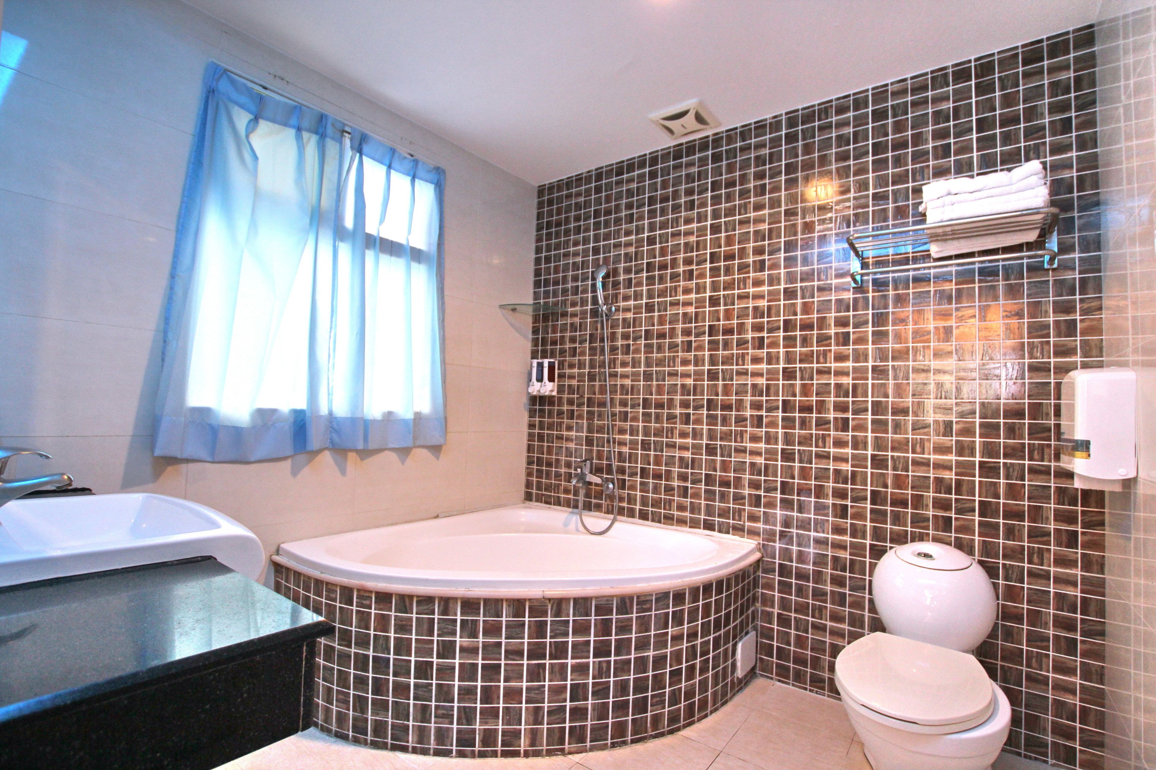 A bathroom with a bathtub, toilet, and sink.