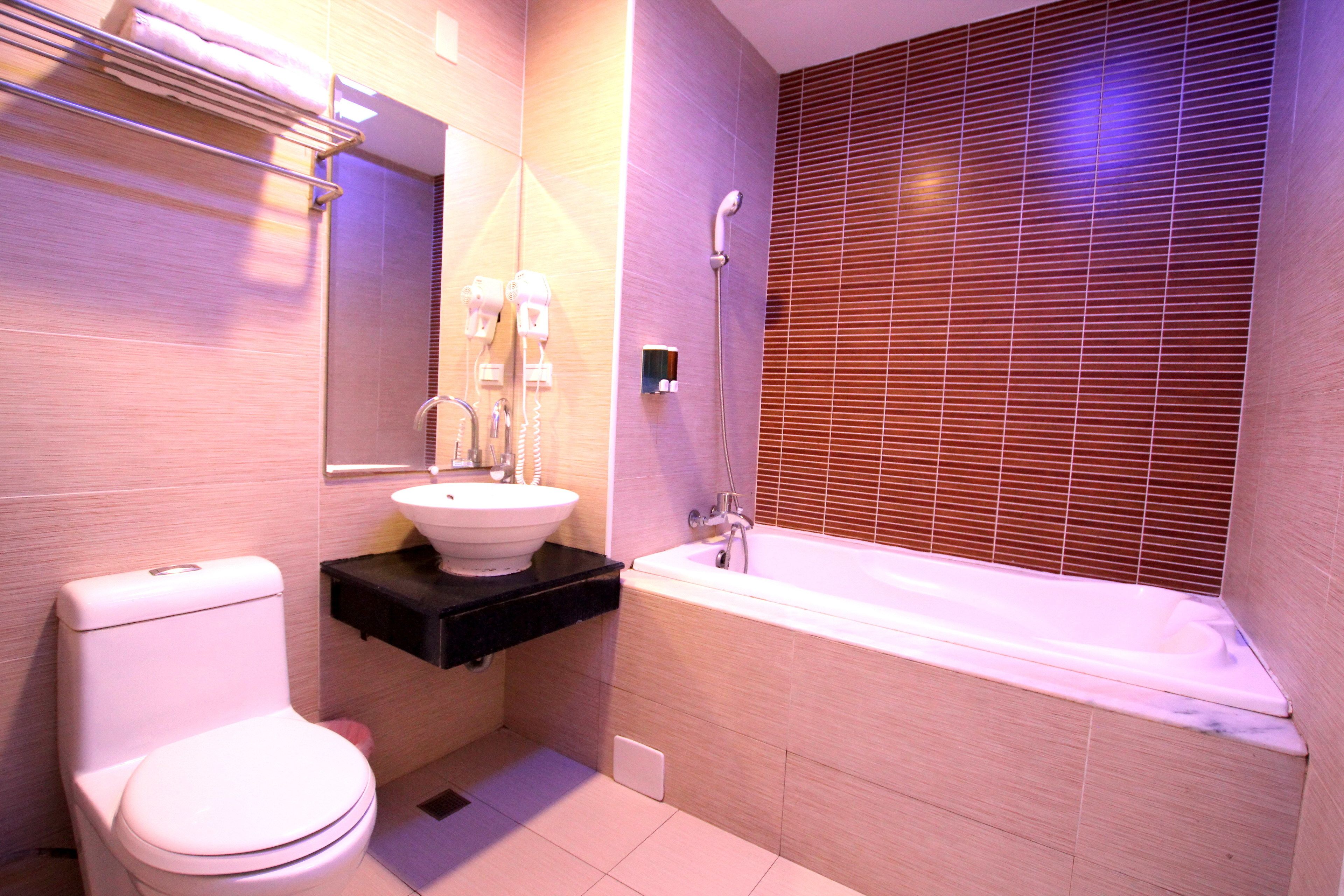 A modern bathroom with a toilet, sink, and bathtub.