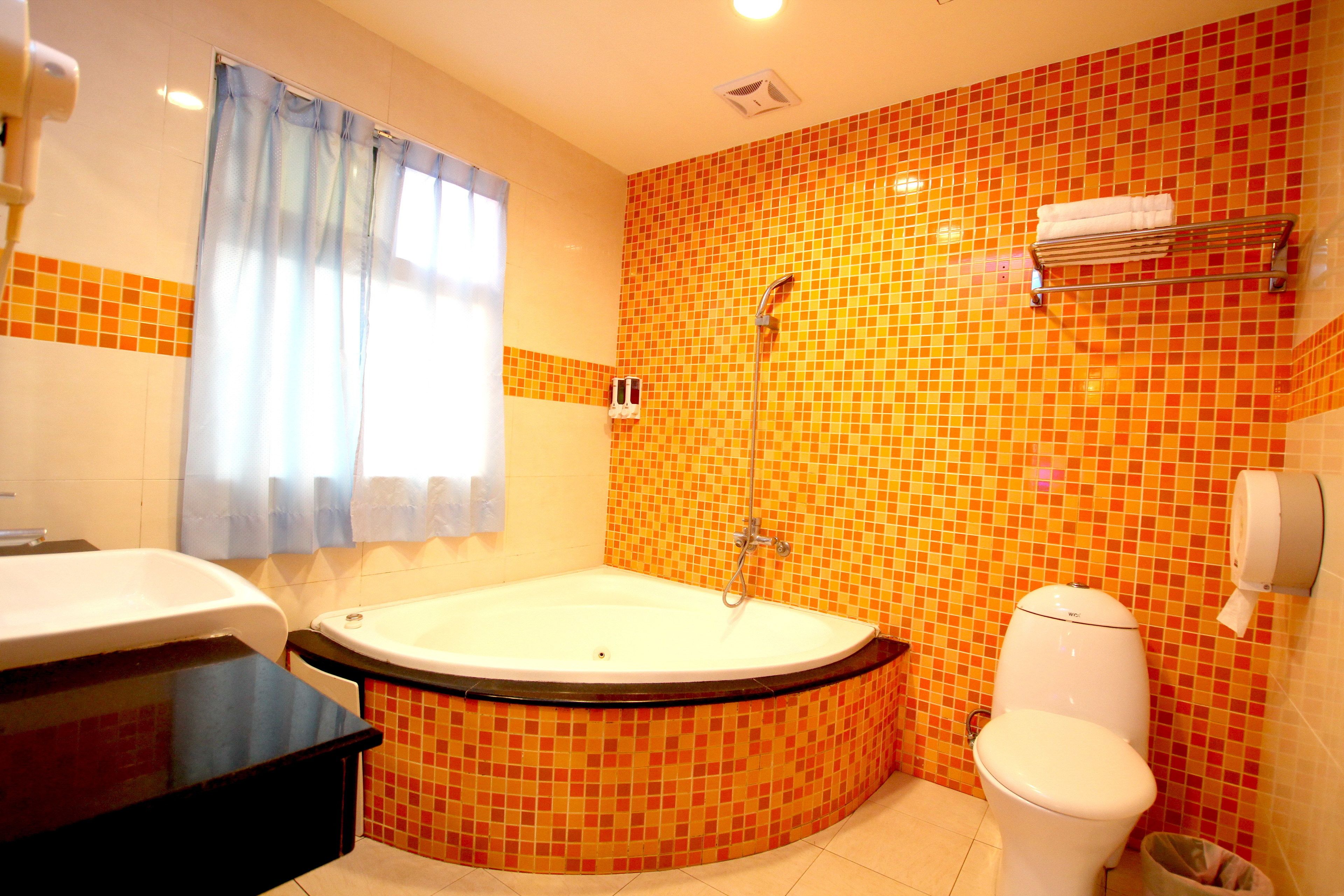 A bathroom with a bathtub, toilet, and sink.