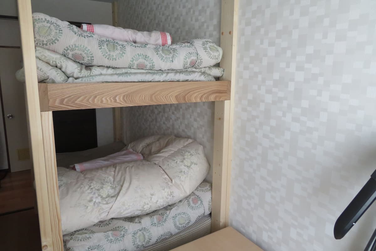 A bunk bed with patterned bedding and a wooden frame.