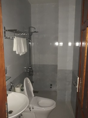 A bathroom with a toilet, sink, and shower.