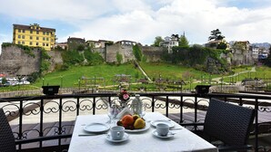 A table set for dining with a view of a historic fort and surrounding buildings. - Zagnospasa Konaklari (Trabzon)