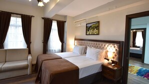 A hotel room with a double bed, a sofa, a nightstand, and a large mirror. - Zagnospasa Konaklari (Trabzon)