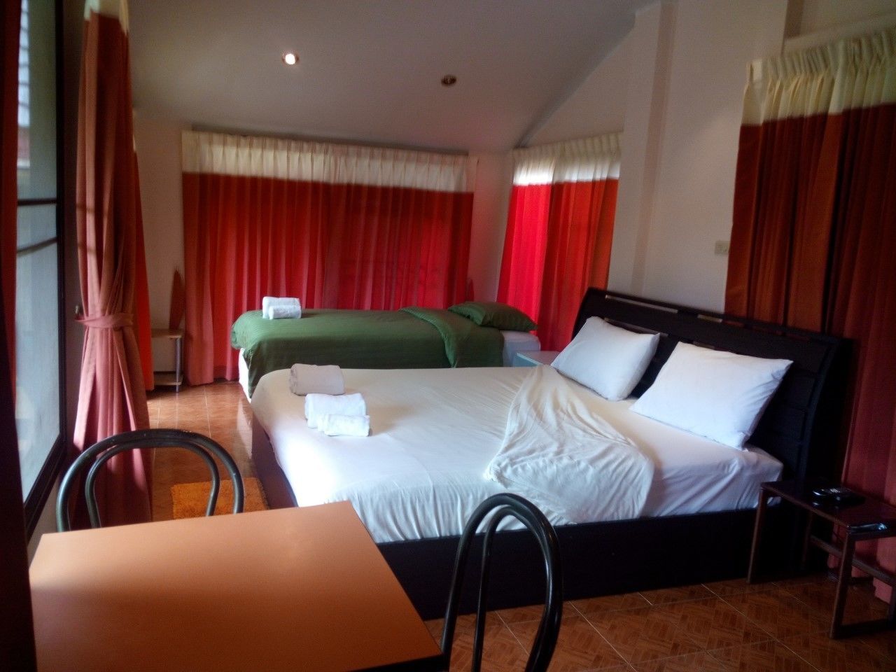A hotel room with a bed, a table, and a chair.