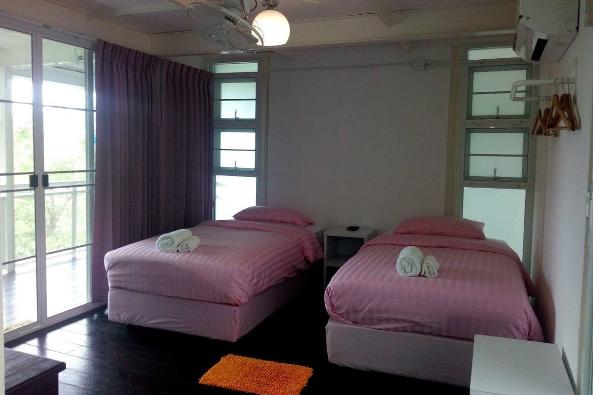 A room with two beds, a small table, and a window.
