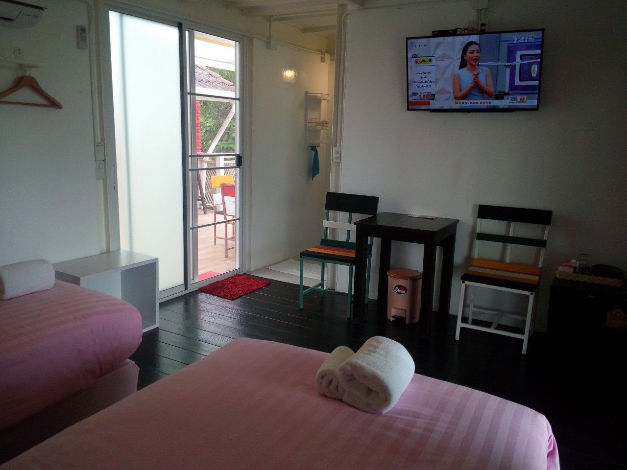 A hotel room with two beds, a TV, a small table, and a chair.