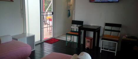Habitación de hotel con dos camas, un televisor, una mesita y una silla.