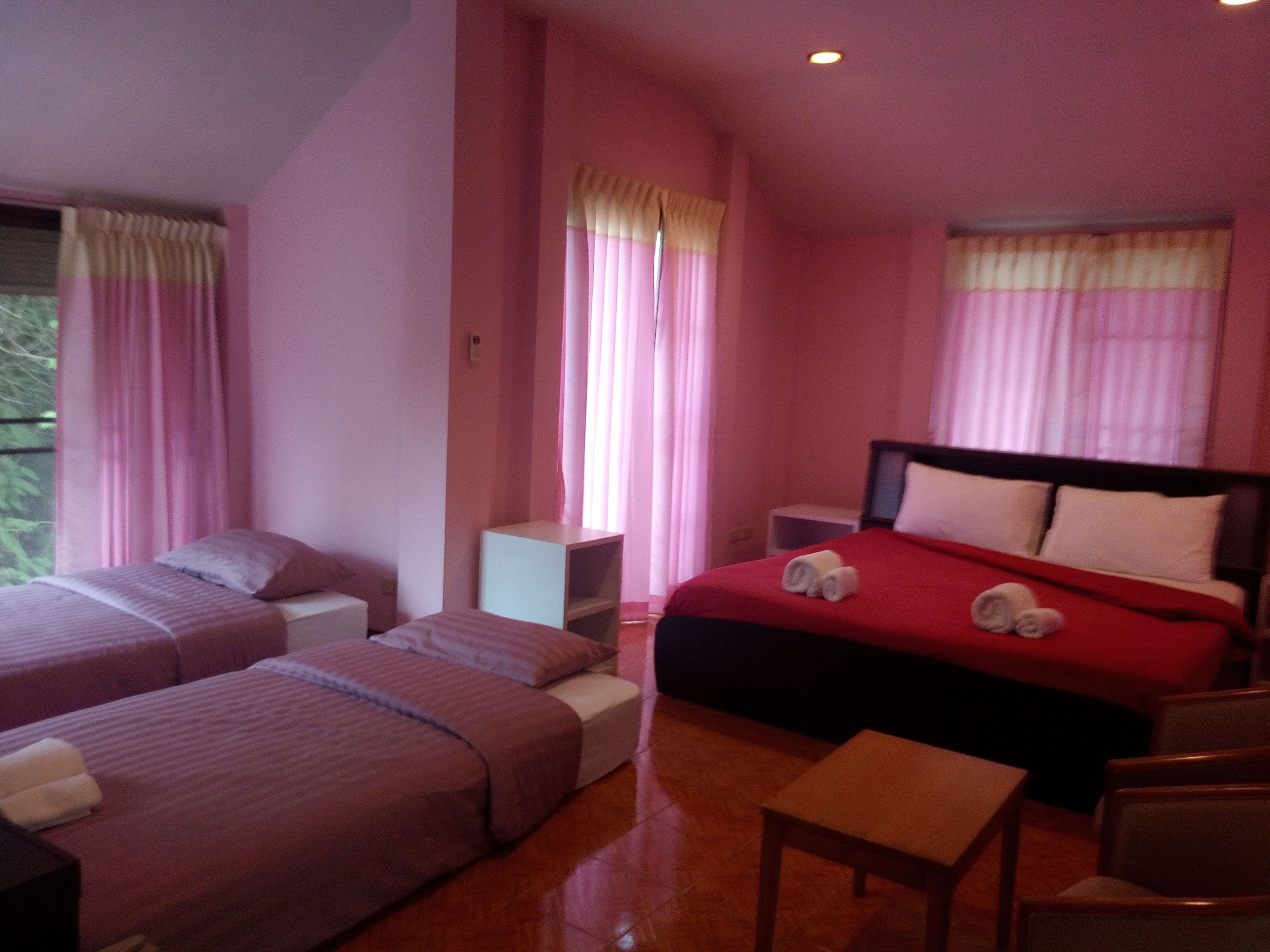 Habitación de hotel con dos camas, una mesita y una silla.
