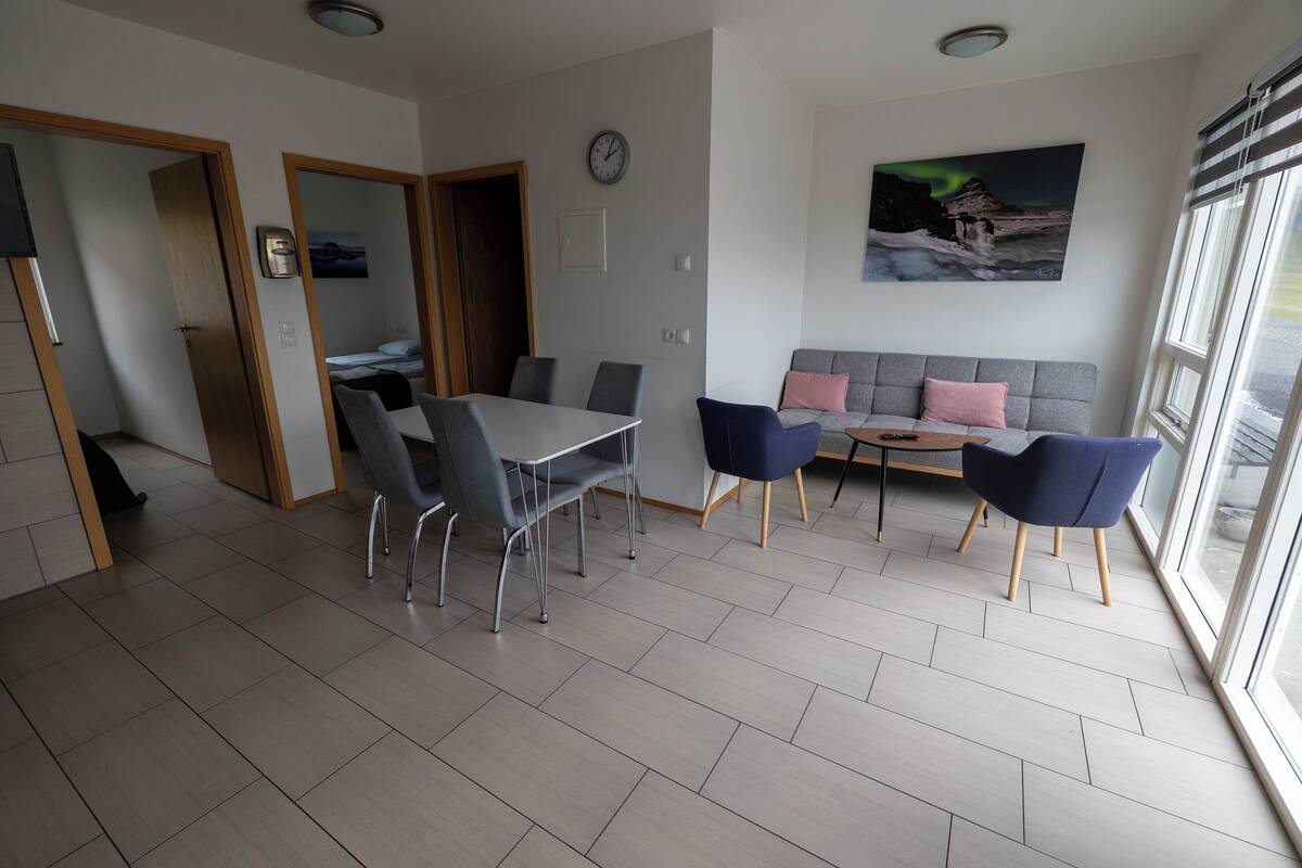 Un salon moderne comprenant une table à manger, des chaises, un canapé et une grande fenêtre offrant une belle vue.