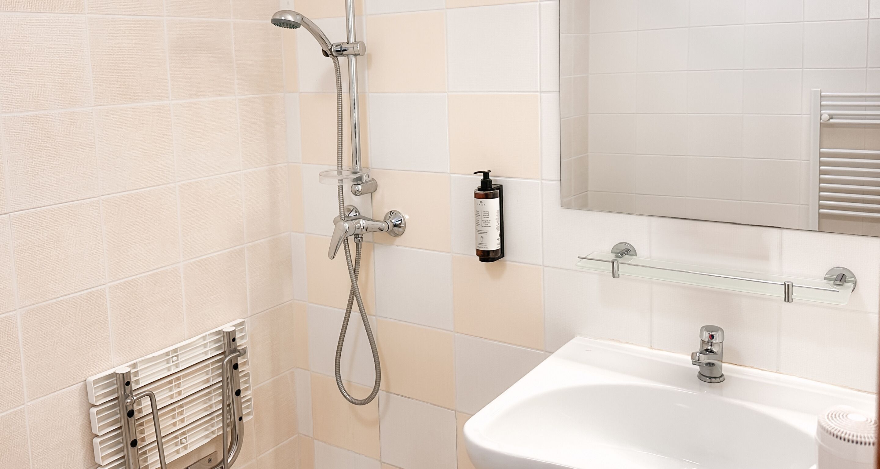 A bathroom with a shower, sink, and mirror.