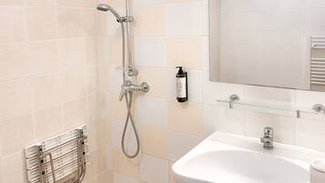 A bathroom with a shower, sink, and mirror.