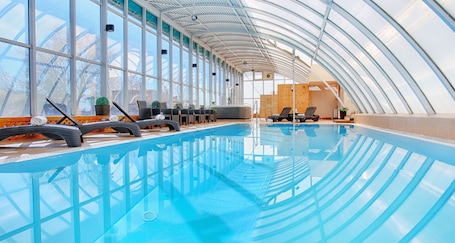 Una piscina techada, sillones reclinables de piscina