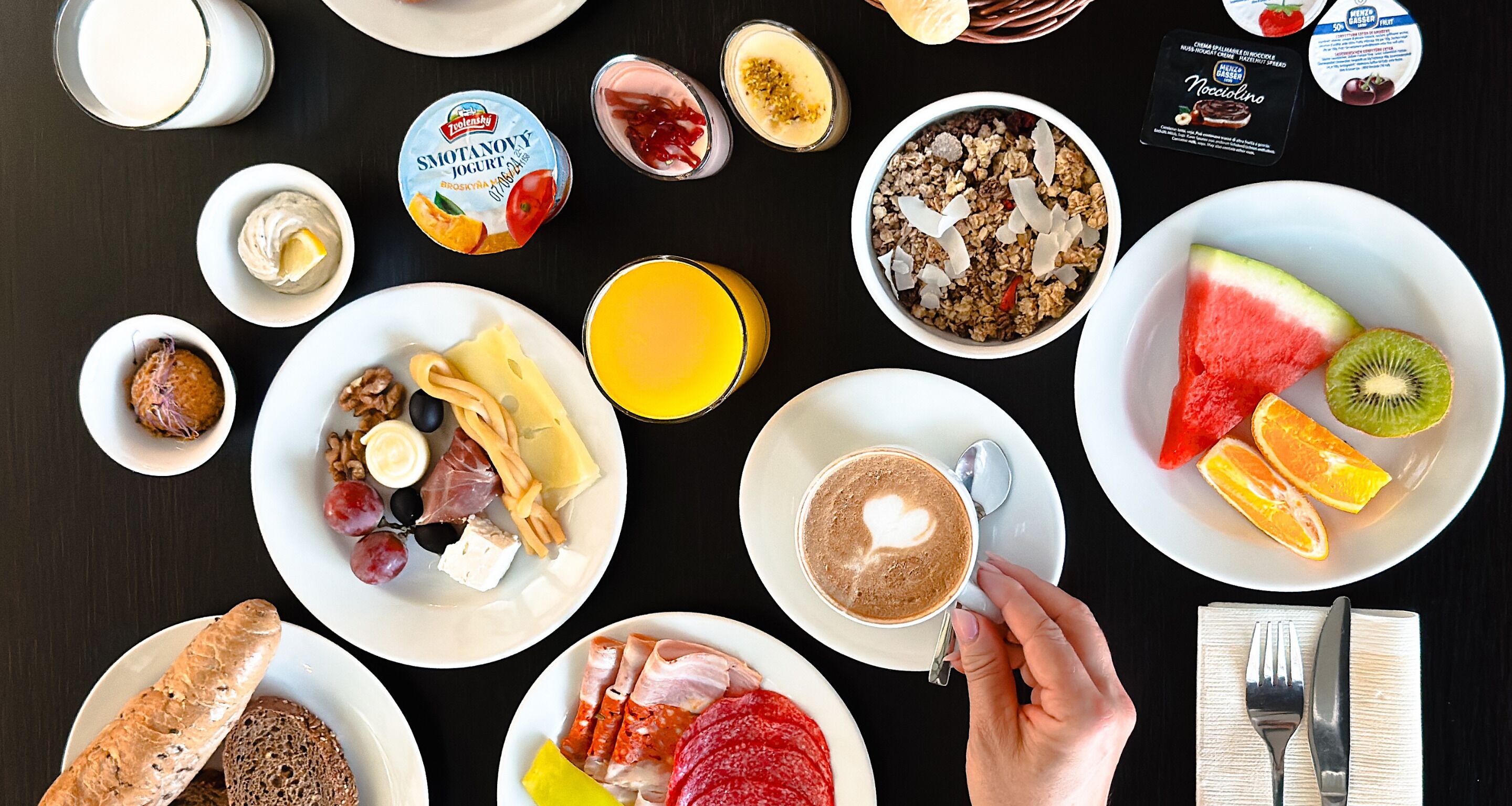 Un desayuno con diferentes alimentos y una taza de café sobre una mesa.