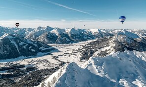 Un paysage montagneux, avec des sommets enneigés et une vallée en contrebas.