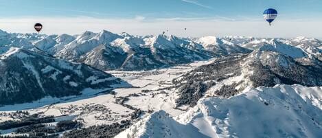 Eine gebirgige Landschaft mit schneebedeckten Gipfeln und einem Tal darunter.