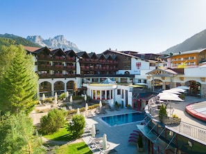 Un hôtel doté d’une piscine, d’un espace extérieur aménagé et offrant une vue sur les montagnes.