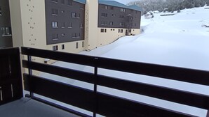 A modern building with multiple floors, large windows, and a snow-covered landscape in the background. - Renovated studio, 5 pers, near slopes, pets allowed (Montgenèvre)