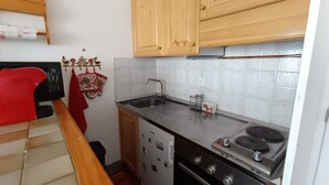 A compact kitchen with wooden cabinets, a stainless steel sink, a microwave, a stove, and a dishwasher. - Renovated studio, 5 pers, near slopes, pets allowed (Montgenèvre)