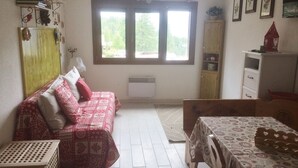 A room with a bed, a table, a cabinet, and a window. - Ski-in studio with washing machine for 4, pets allowed (Montgenèvre)