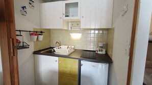 A compact kitchen with white cabinets, a sink, a coffee maker, and a small refrigerator. - Ski-in studio with washing machine for 4, pets allowed (Montgenèvre)