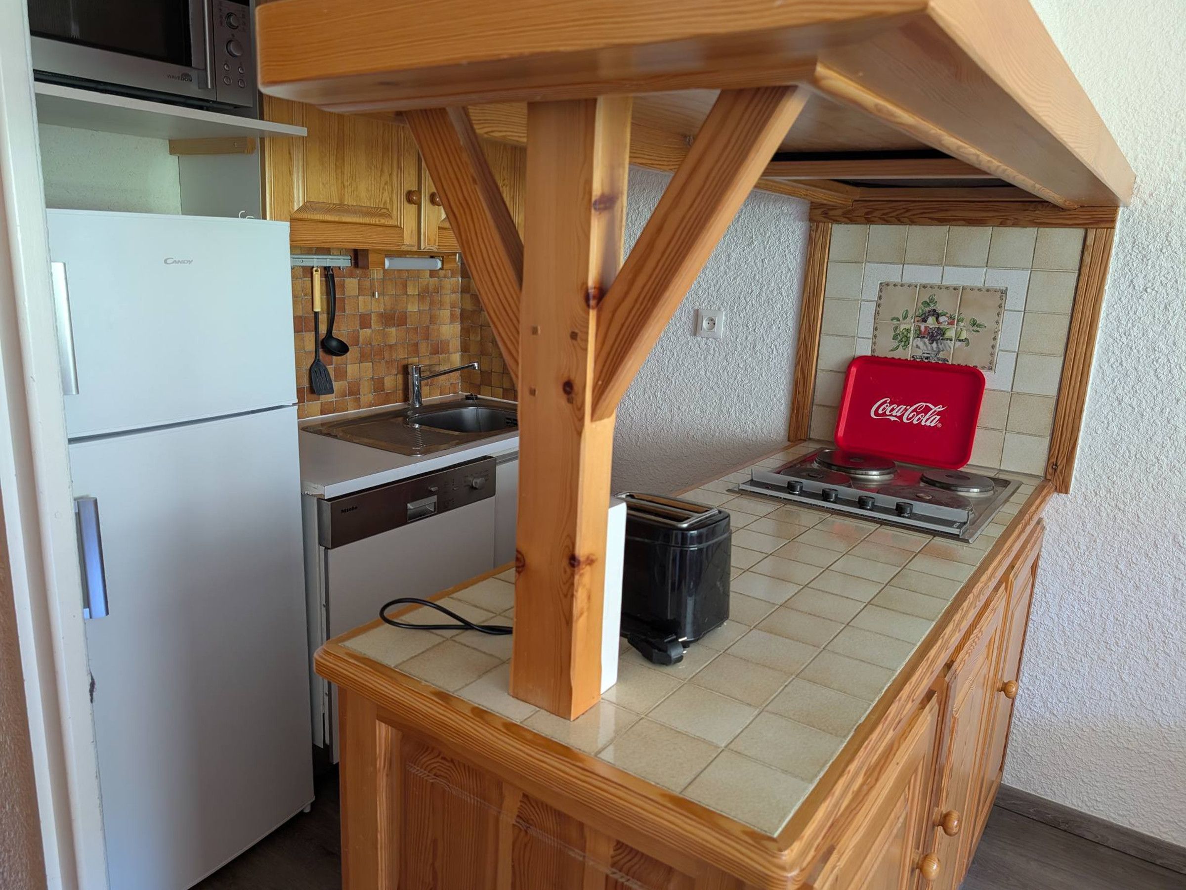 A compact kitchen with a built-in dishwasher, a microwave, a sink, and a stove.